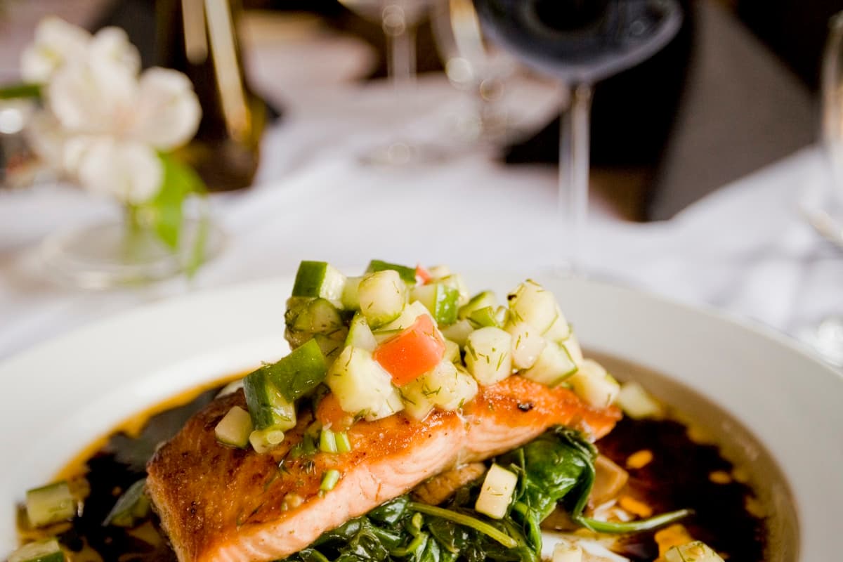 Glazed honey garlic salmon fillet on a plate with sesame seeds and green onions