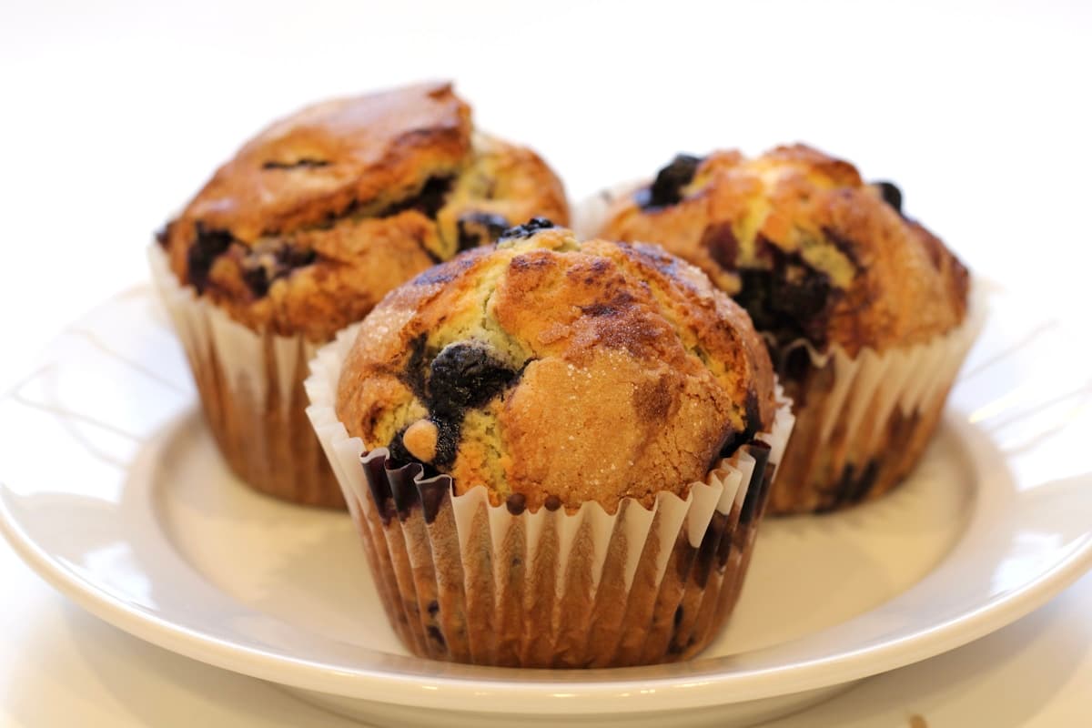 Golden lemon blueberry muffins with crumble topping on a cooling rack