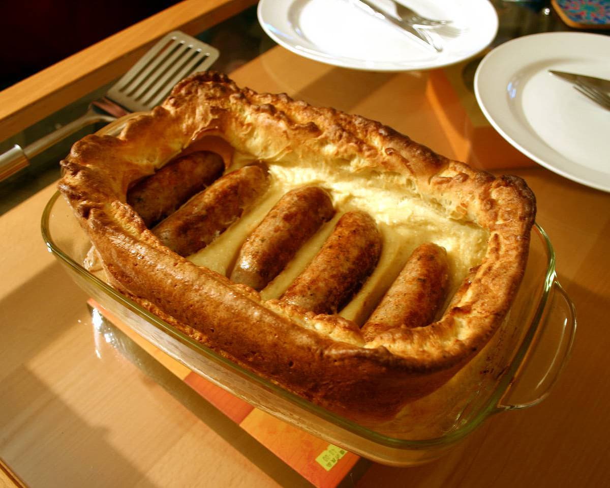 Toad in the hole with sausages baked in puffy Yorkshire pudding batter
