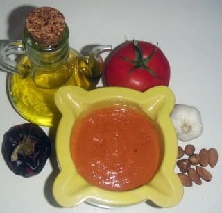 Romesco sauce in a bowl with roasted red peppers and almonds