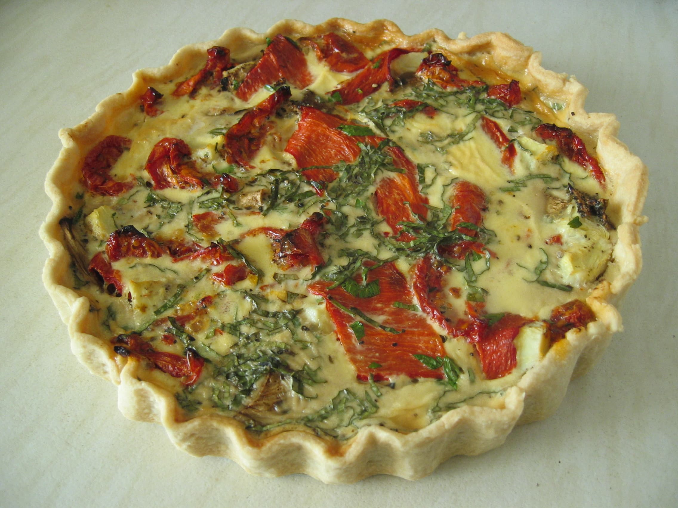 Golden mushroom and spinach quiche with a flaky crust, sliced to show the filling