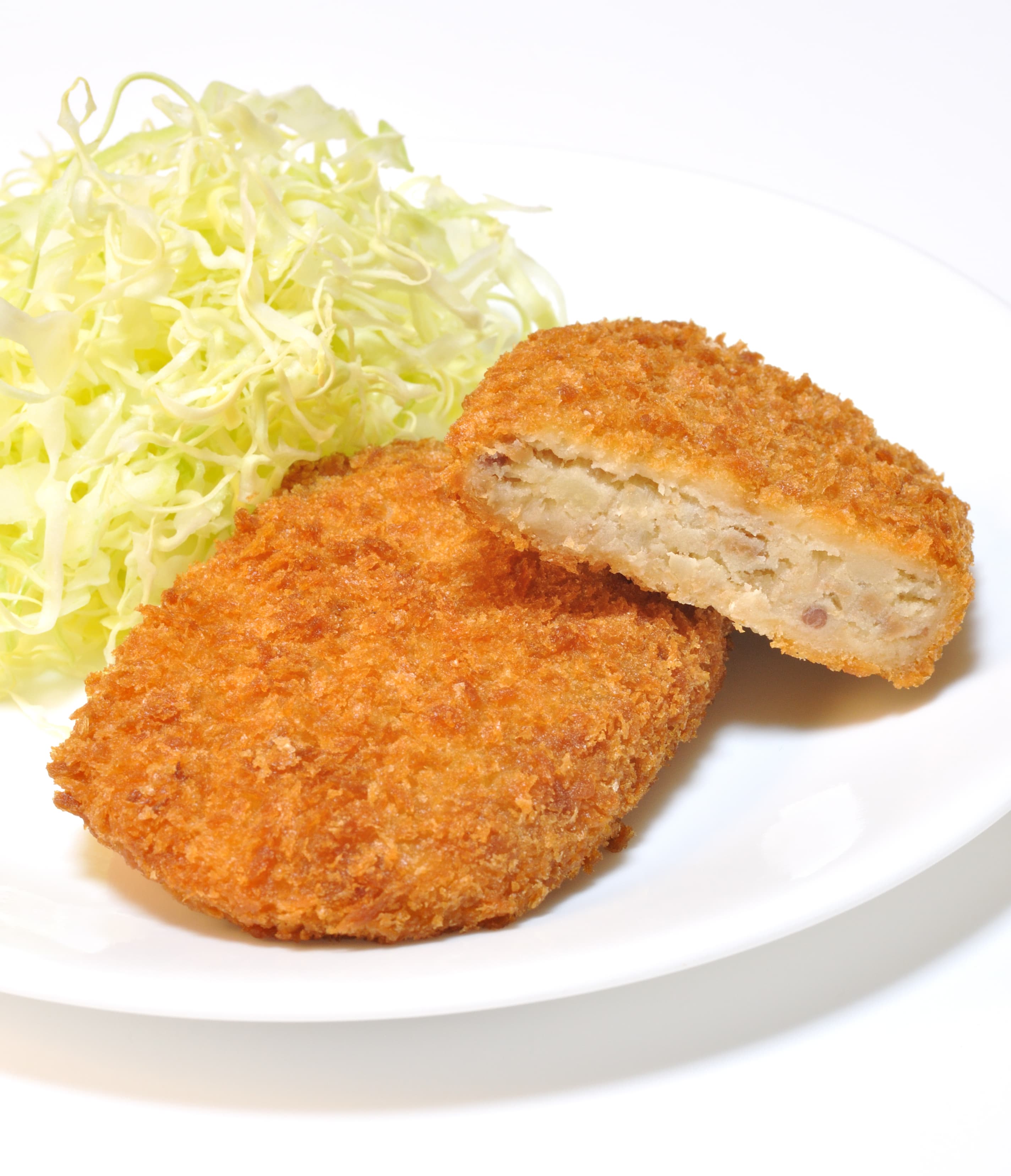 Golden Japanese korokke croquettes on a plate with tonkatsu sauce