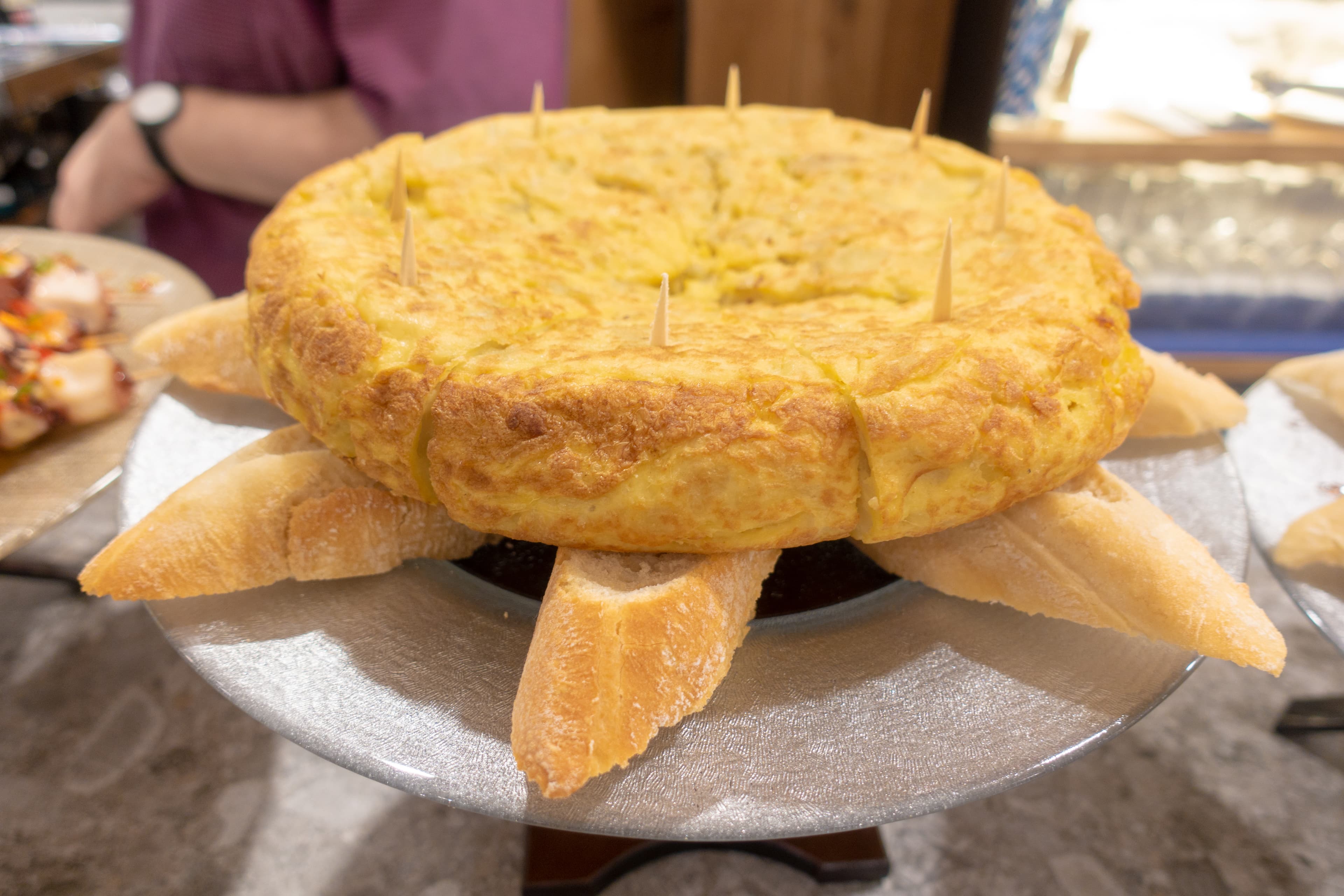 Tortilla espanola cut into wedges showing layers of potato and egg