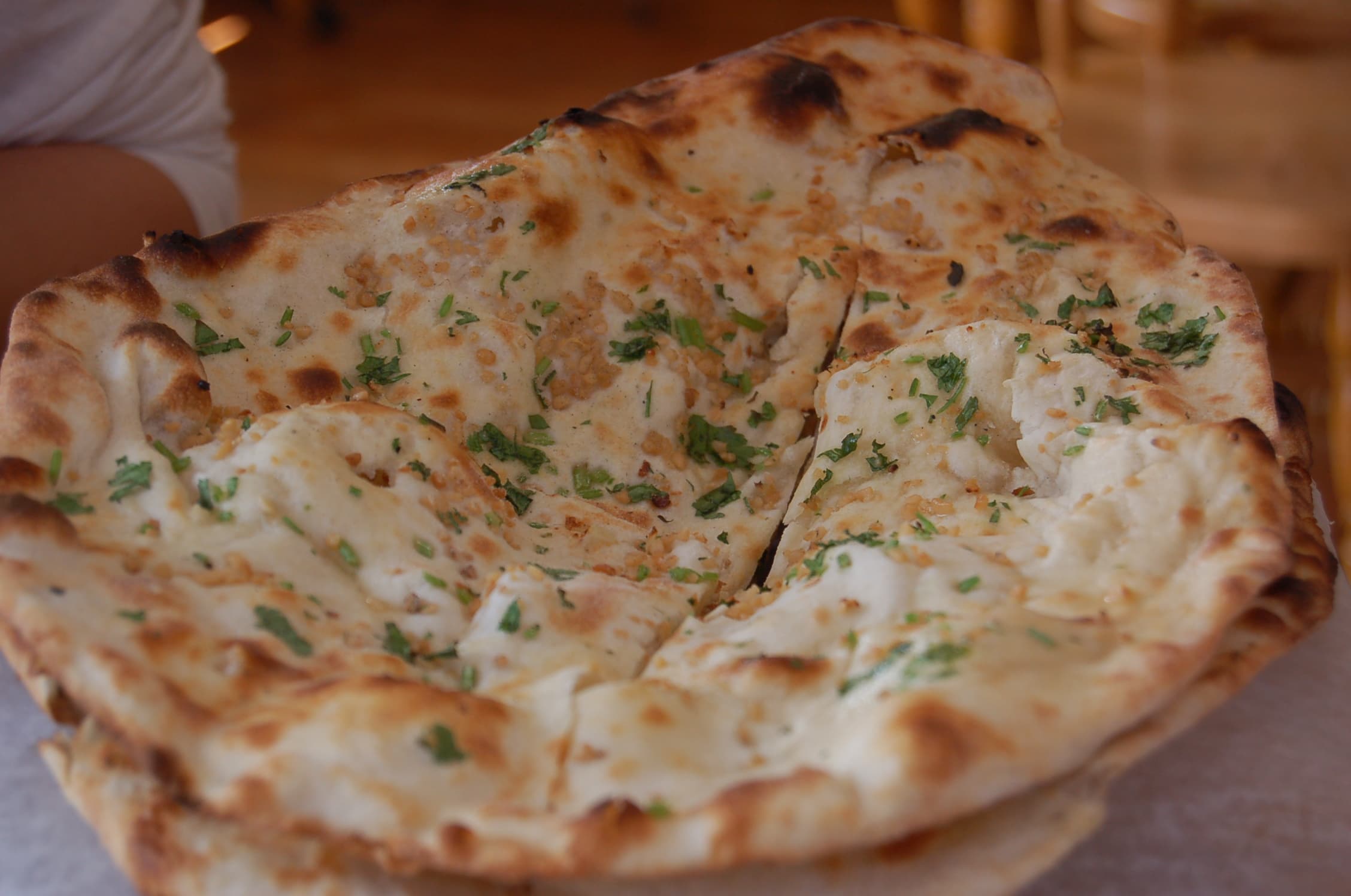 Stack of fresh naan bread brushed with garlic butter