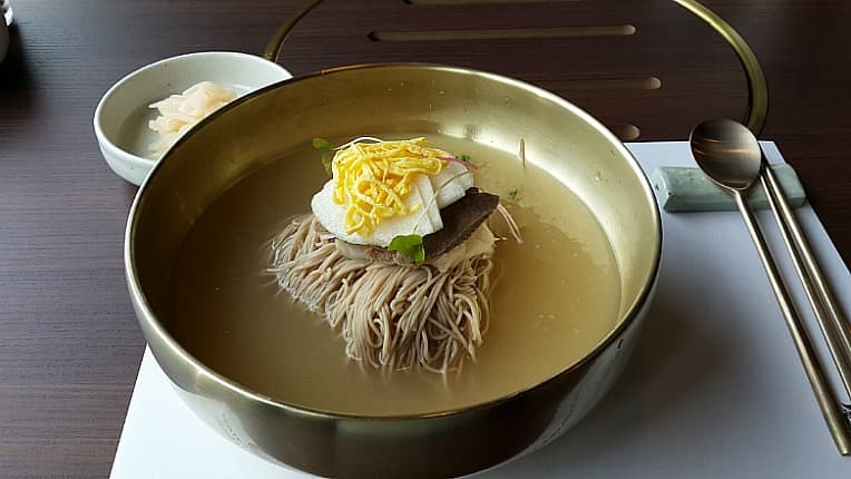 Korean naengmyeon cold noodles in icy broth with egg and brisket