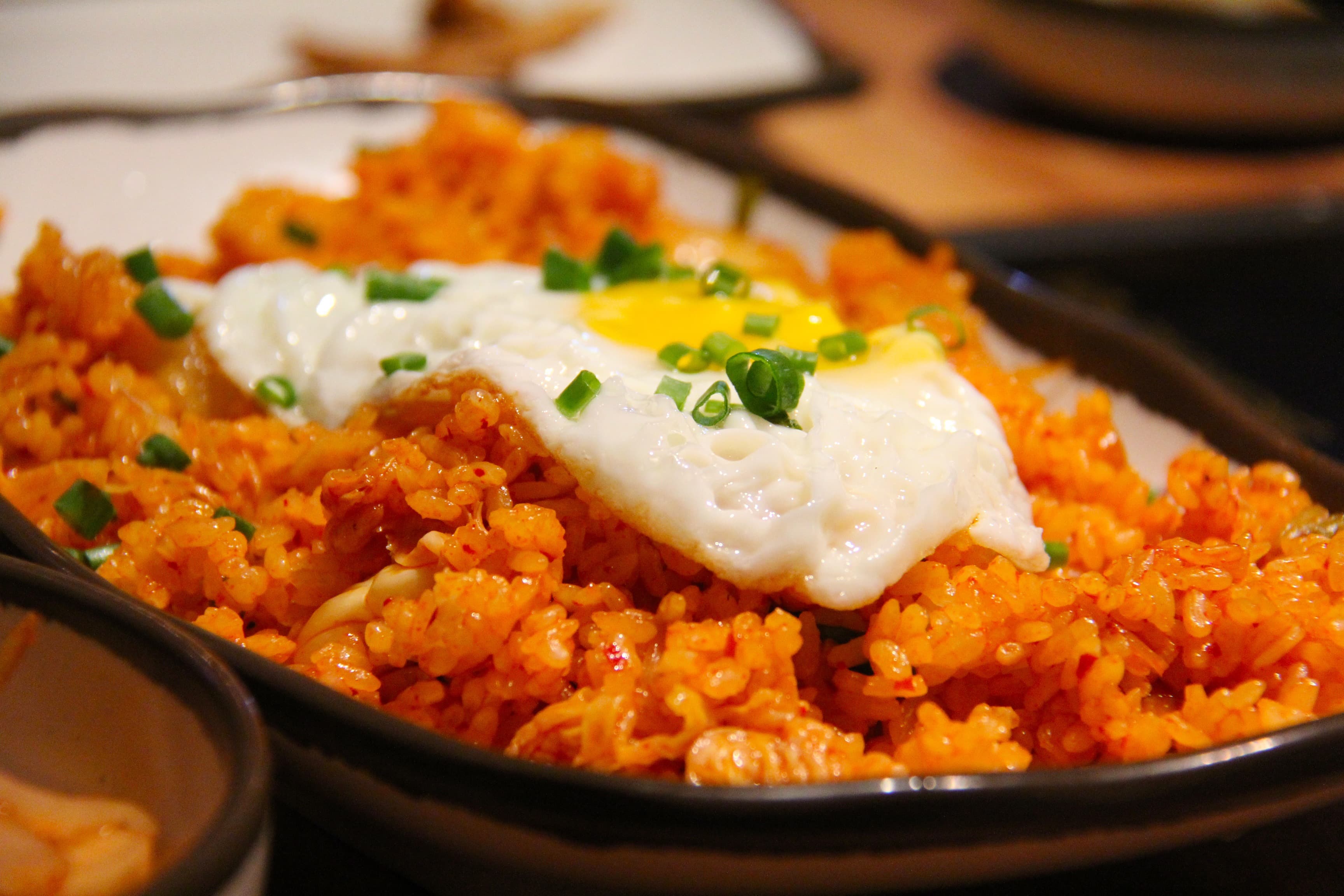 Plate of kimchi fried rice topped with a sunny-side-up egg and sesame seeds