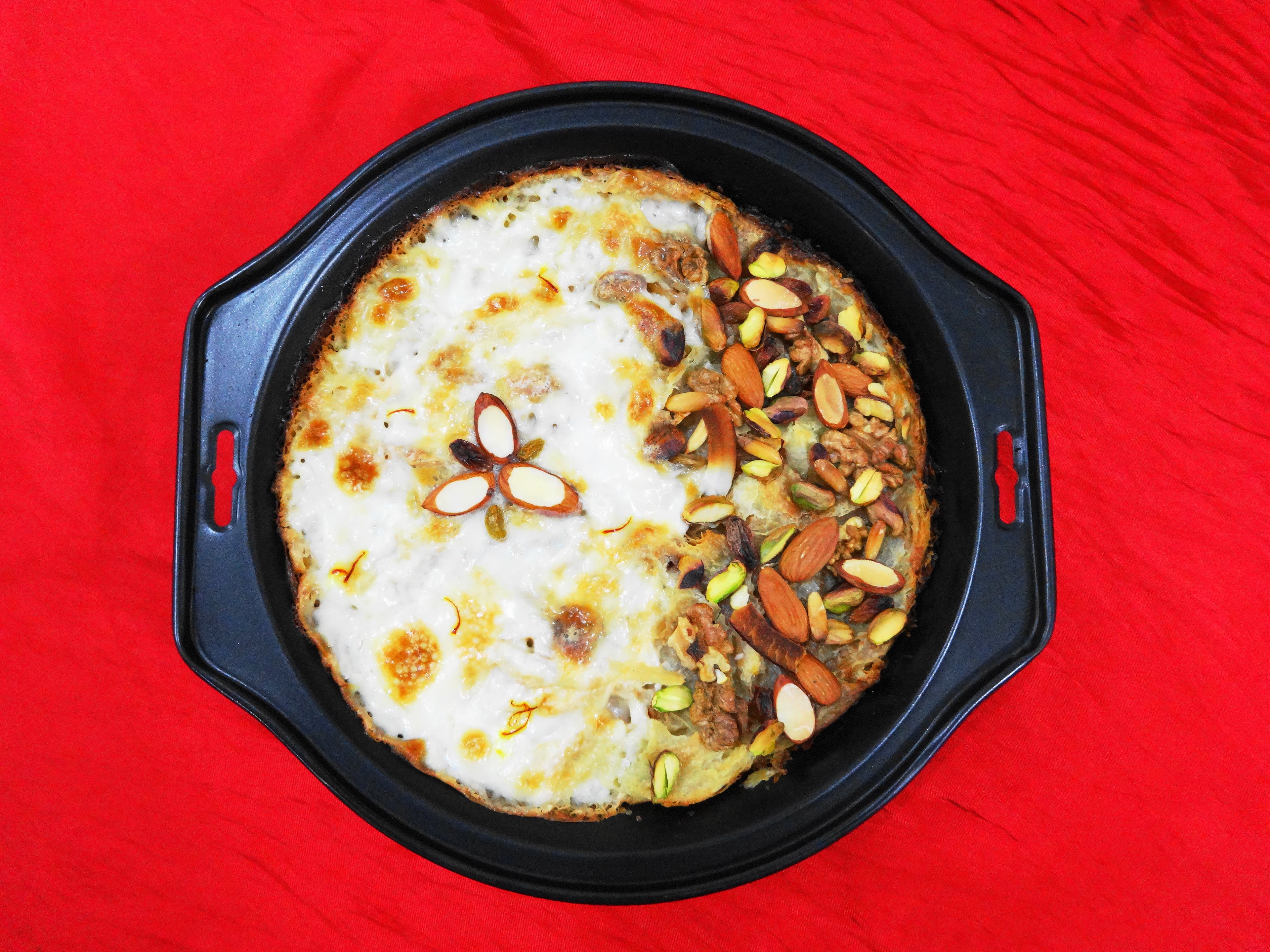 Golden bubbling umm ali dessert with nuts and raisins