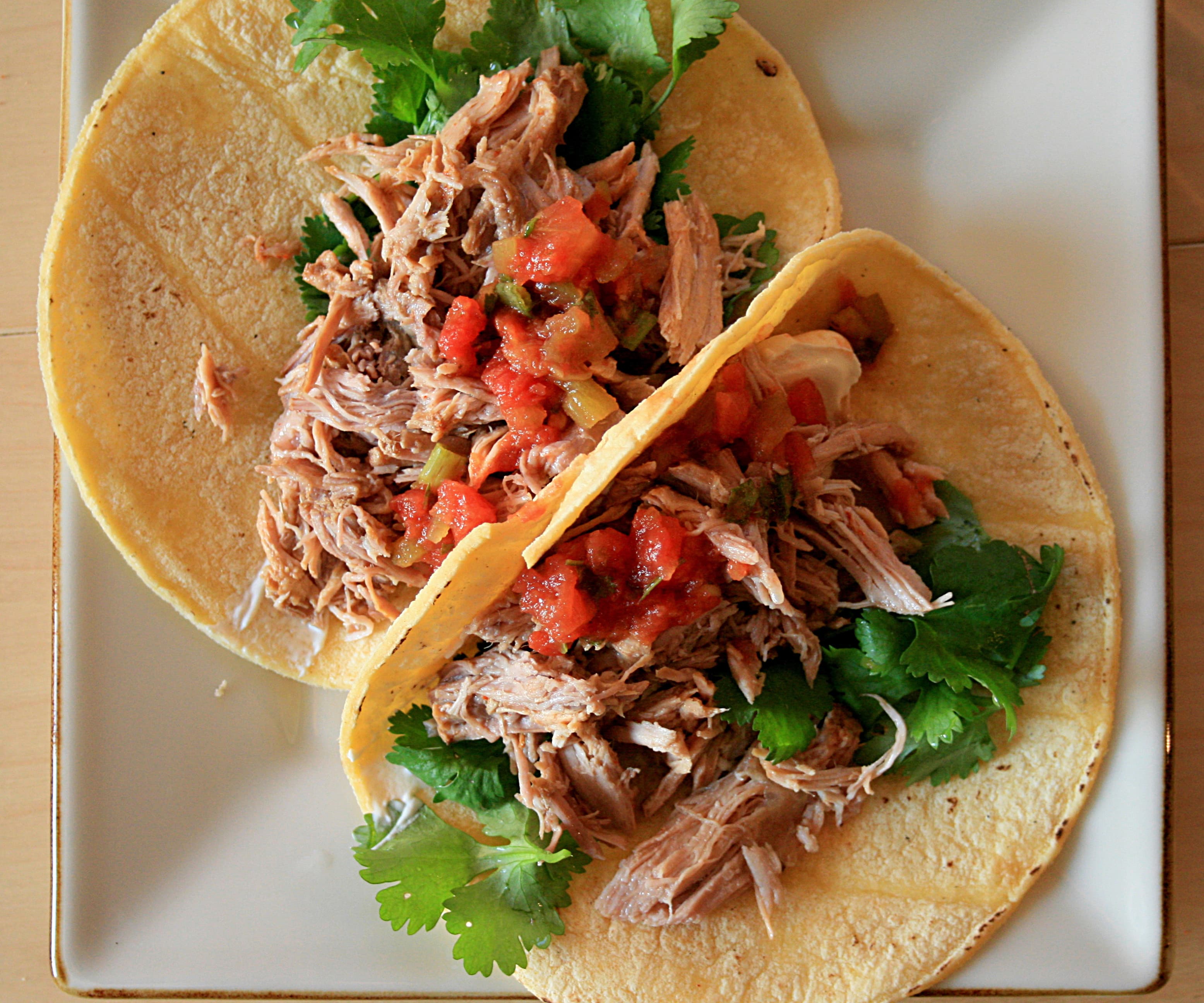 Crispy slow cooker carnitas in tortillas with lime and cilantro