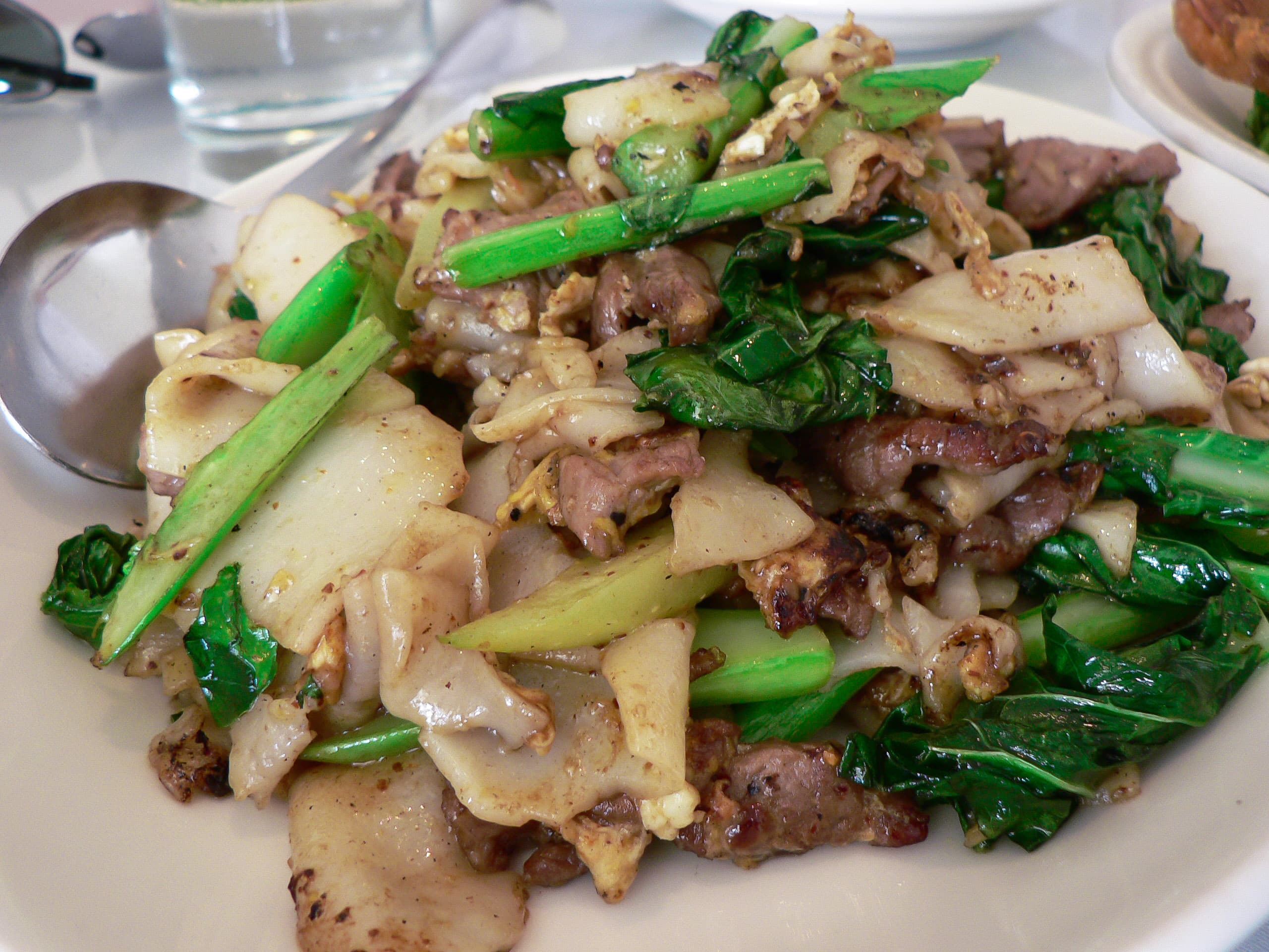 Plate of pad see ew with wide rice noodles, Chinese broccoli, and charred edges