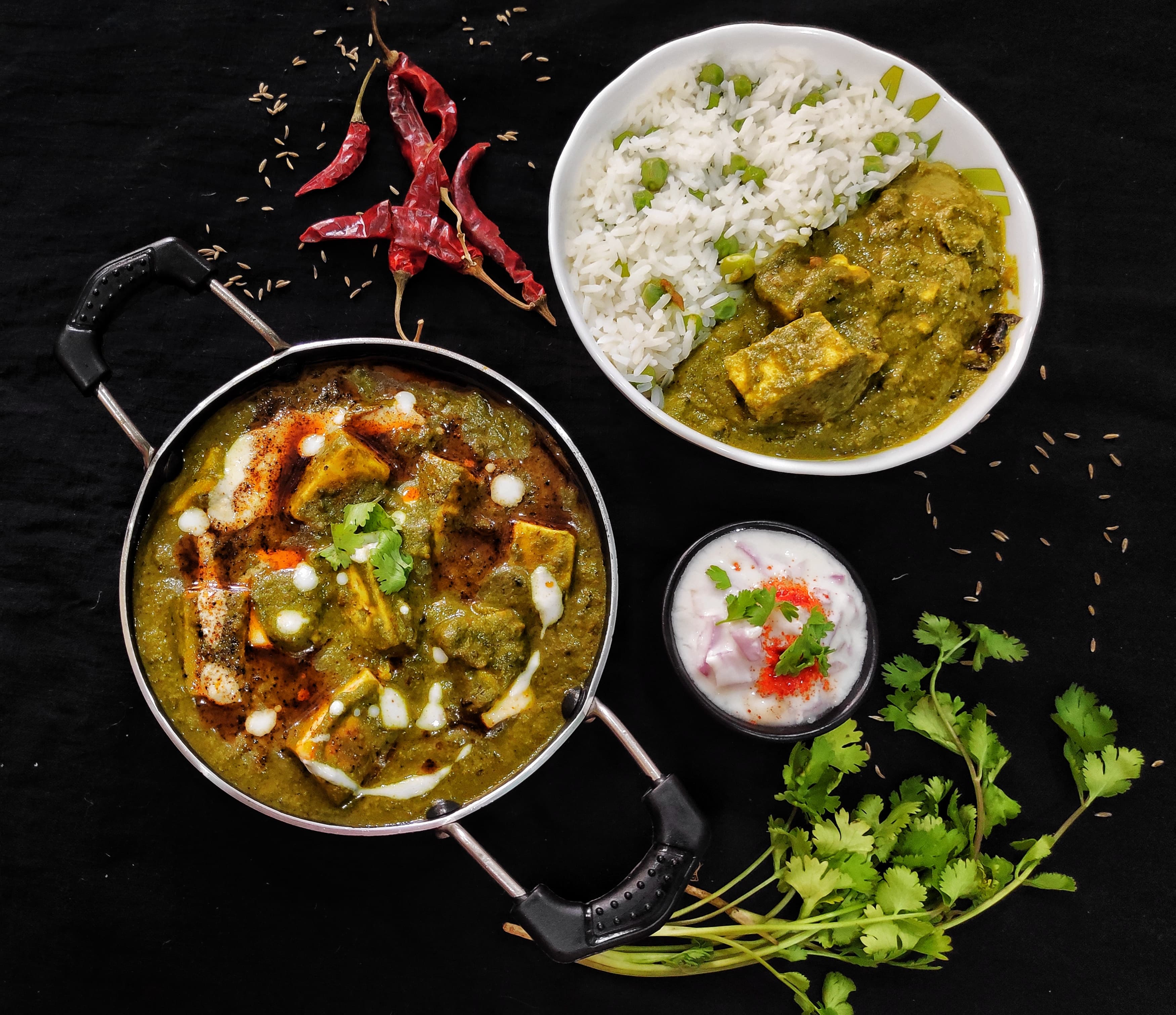 Bowl of palak paneer with golden paneer cubes in bright green spinach sauce