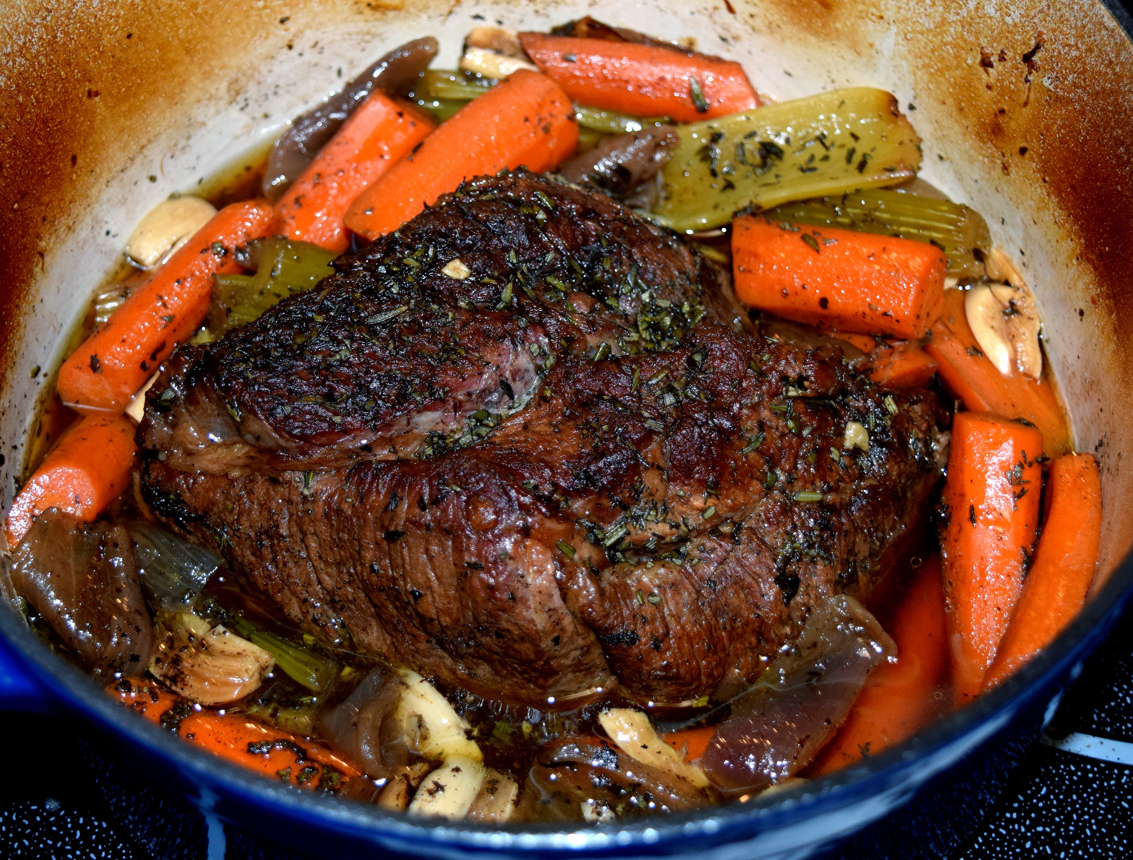 Slow-braised pot roast sliced on a platter with vegetables