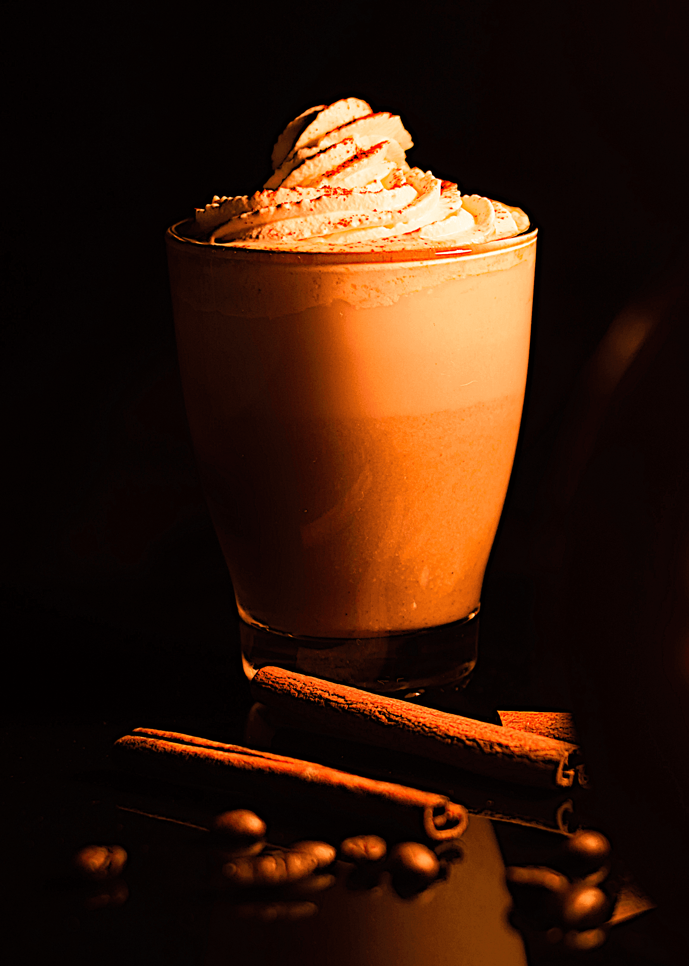 Pumpkin spice latte in a mug with whipped cream and cinnamon sprinkle