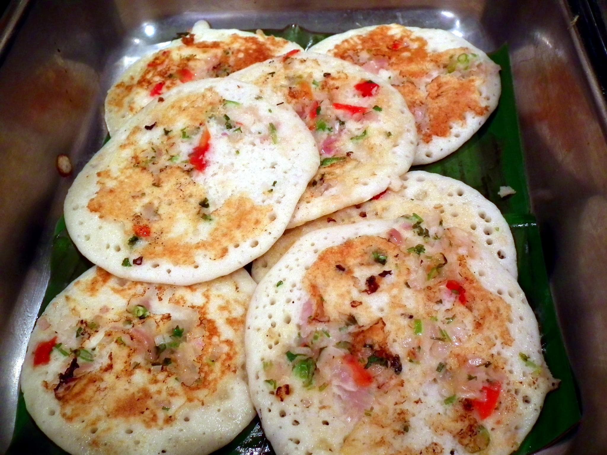 Thick uttapam topped with onions, tomatoes, and green chilies