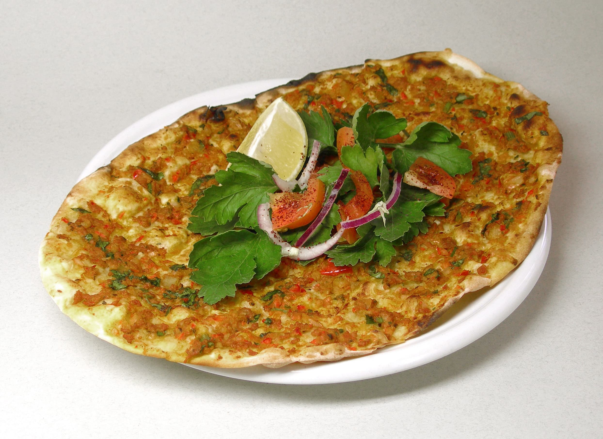 Thin lahmacun Turkish pizza with ground lamb and herbs