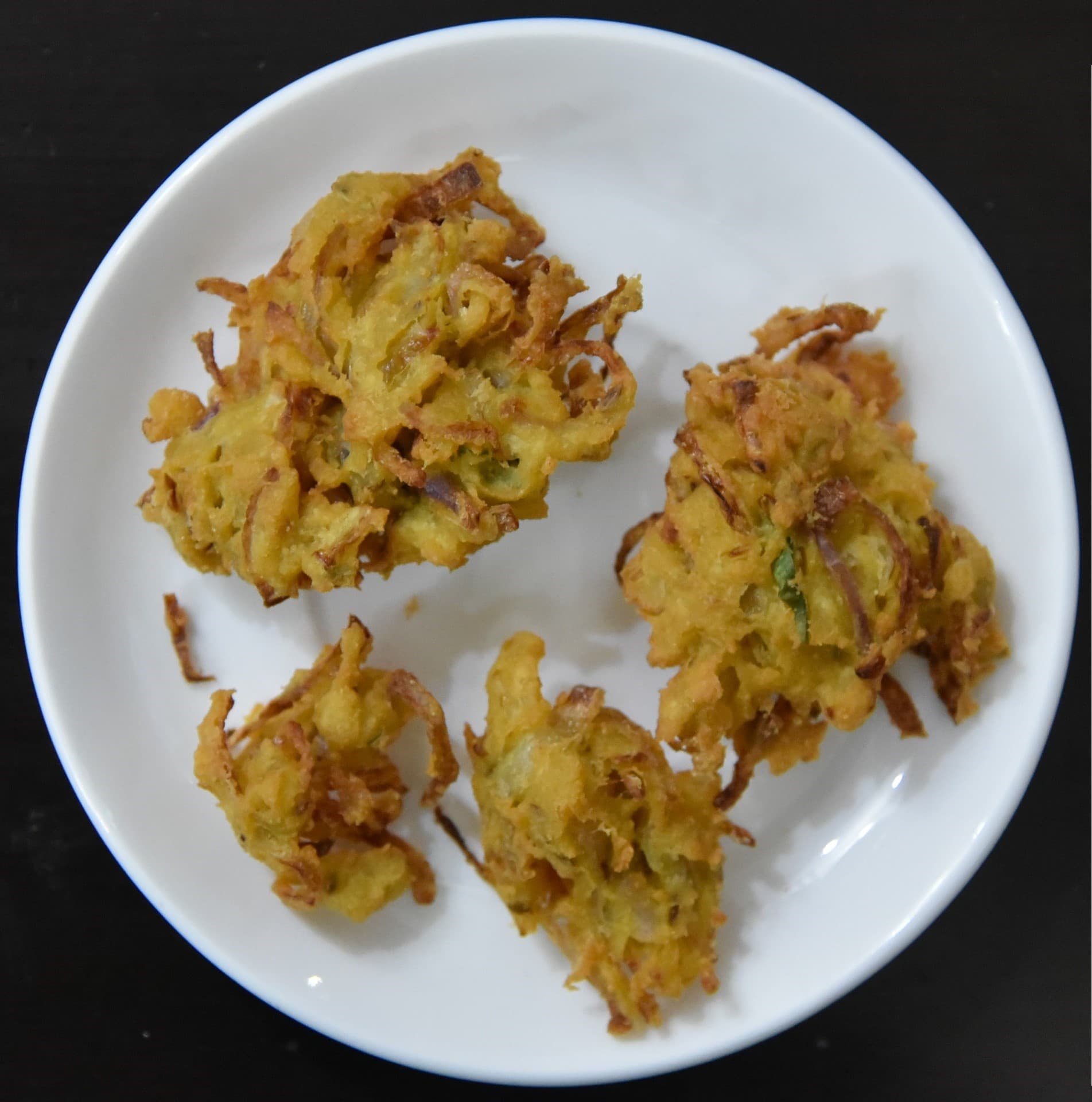 Golden paneer pakora slices with green chutney on the side
