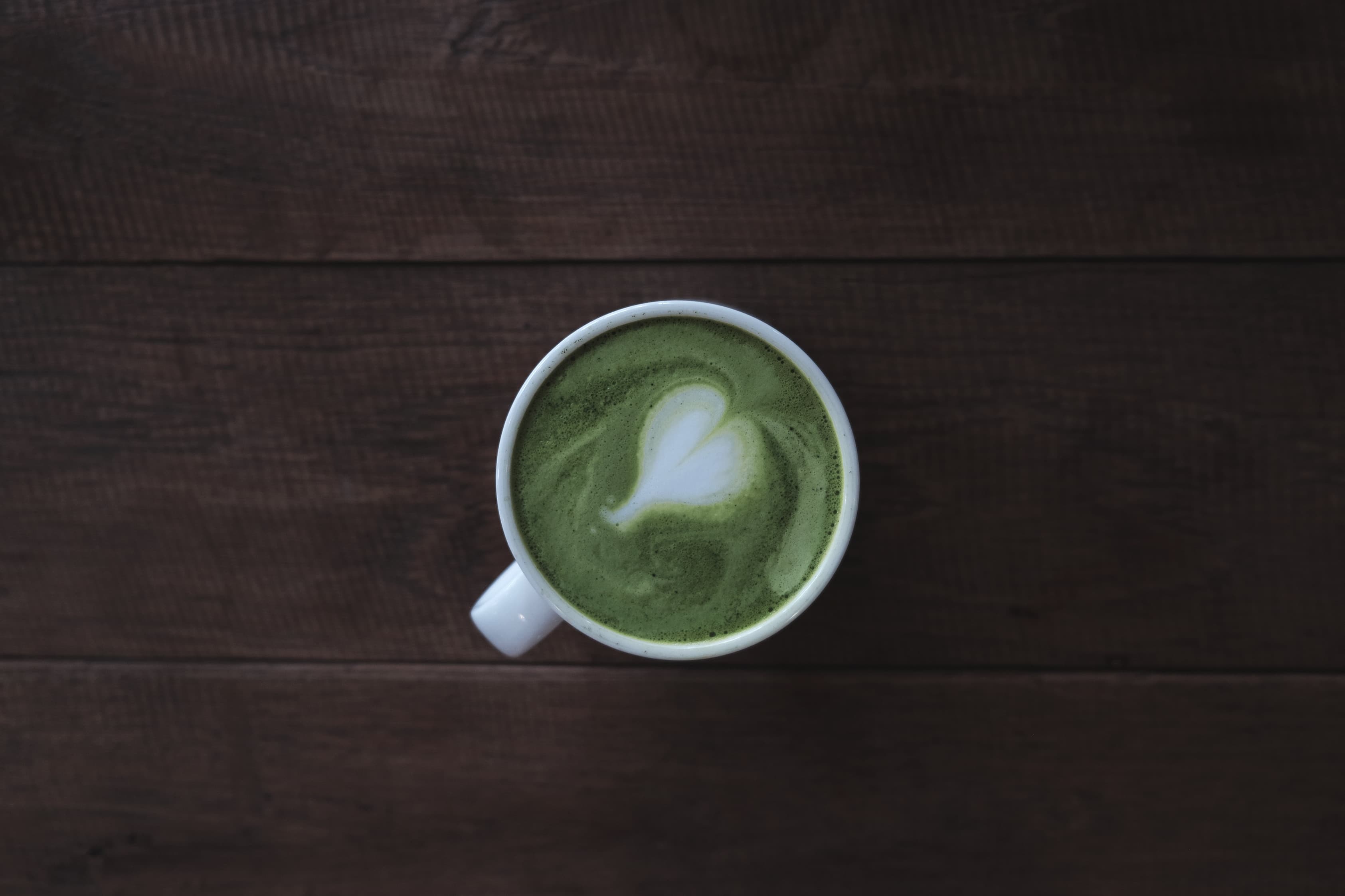 Matcha latte with latte art in a white cup