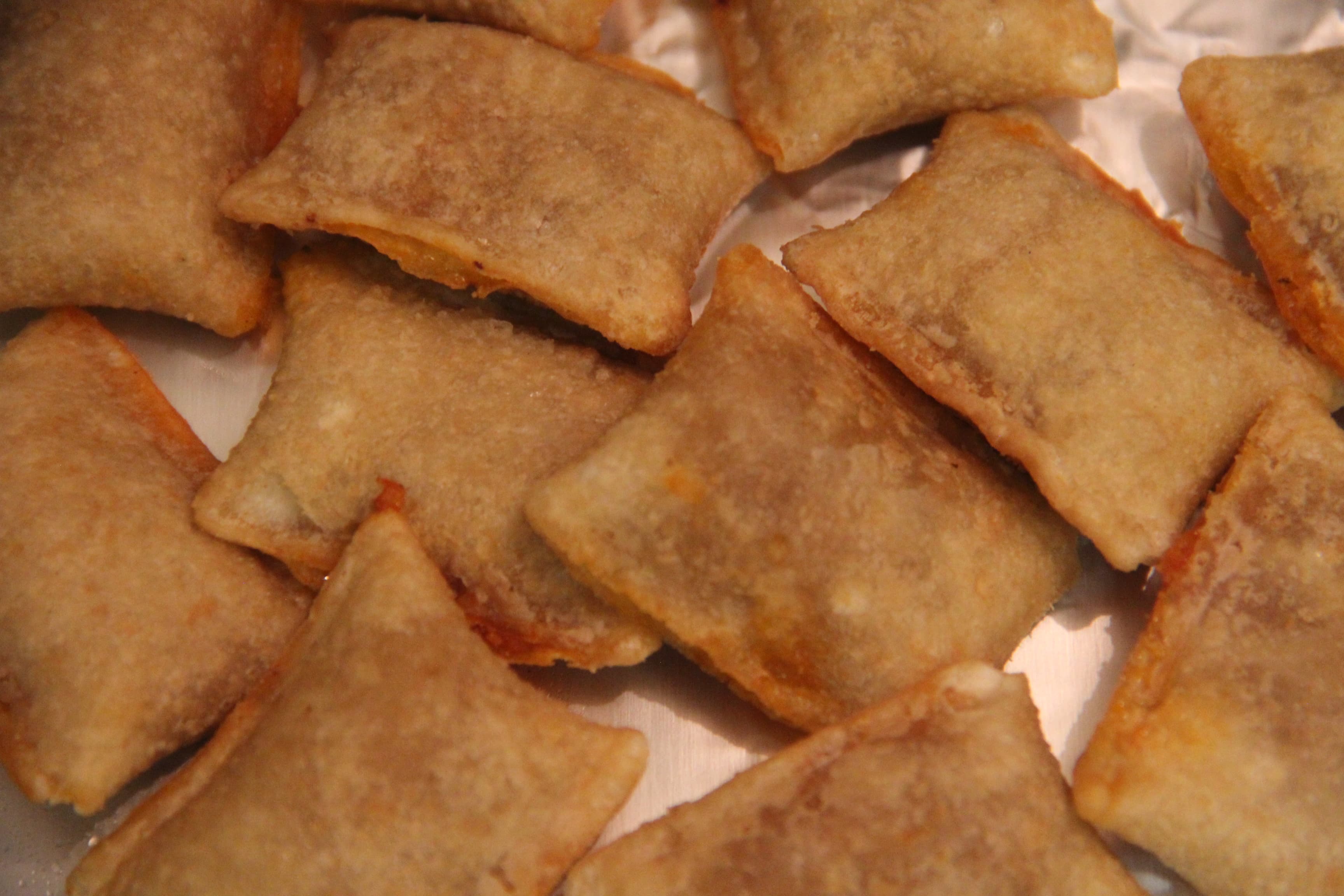 Plate of golden homemade pizza rolls with marinara dipping sauce