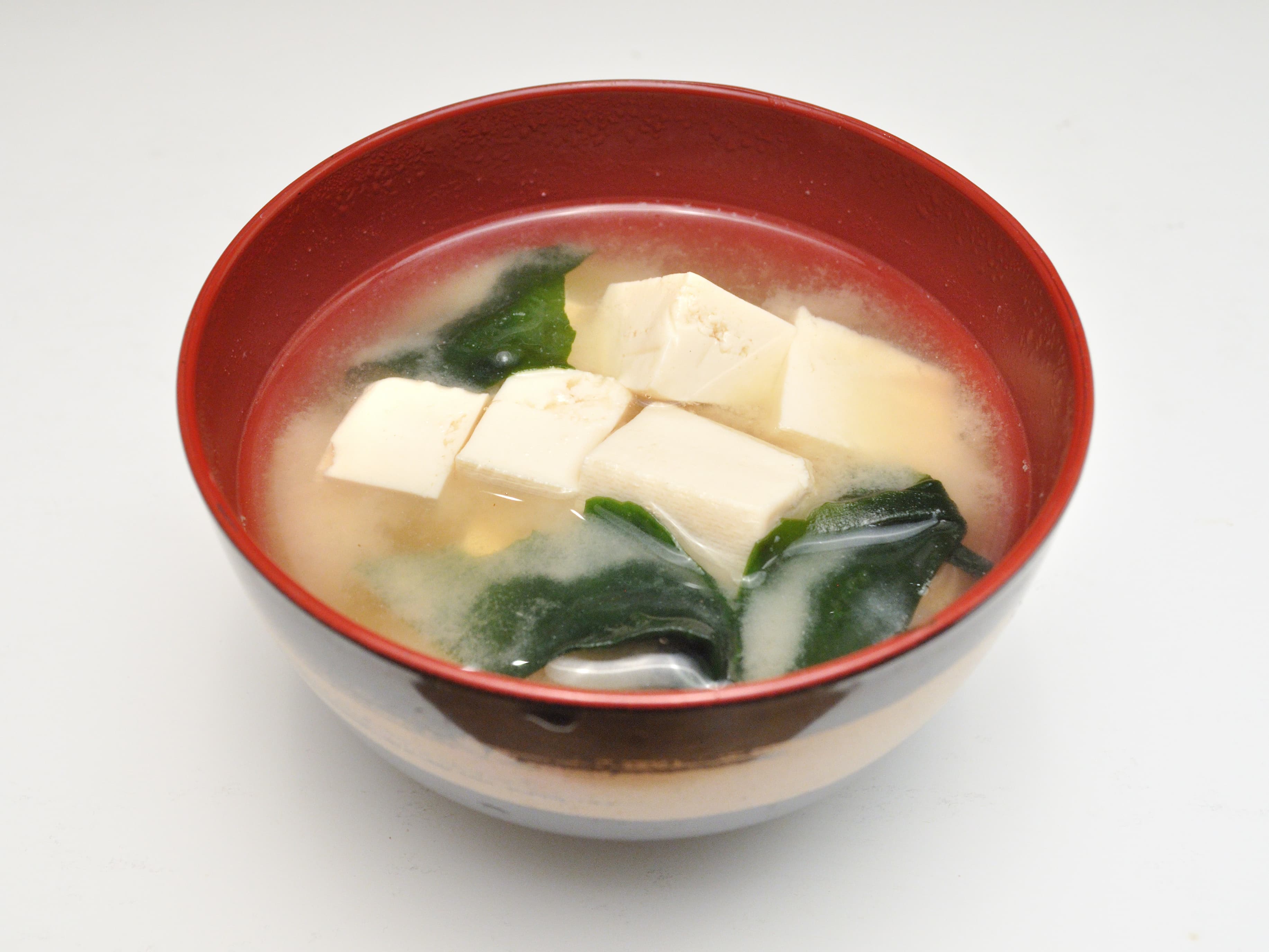 Bowl of simple miso soup with tofu cubes, wakame, and sliced scallions