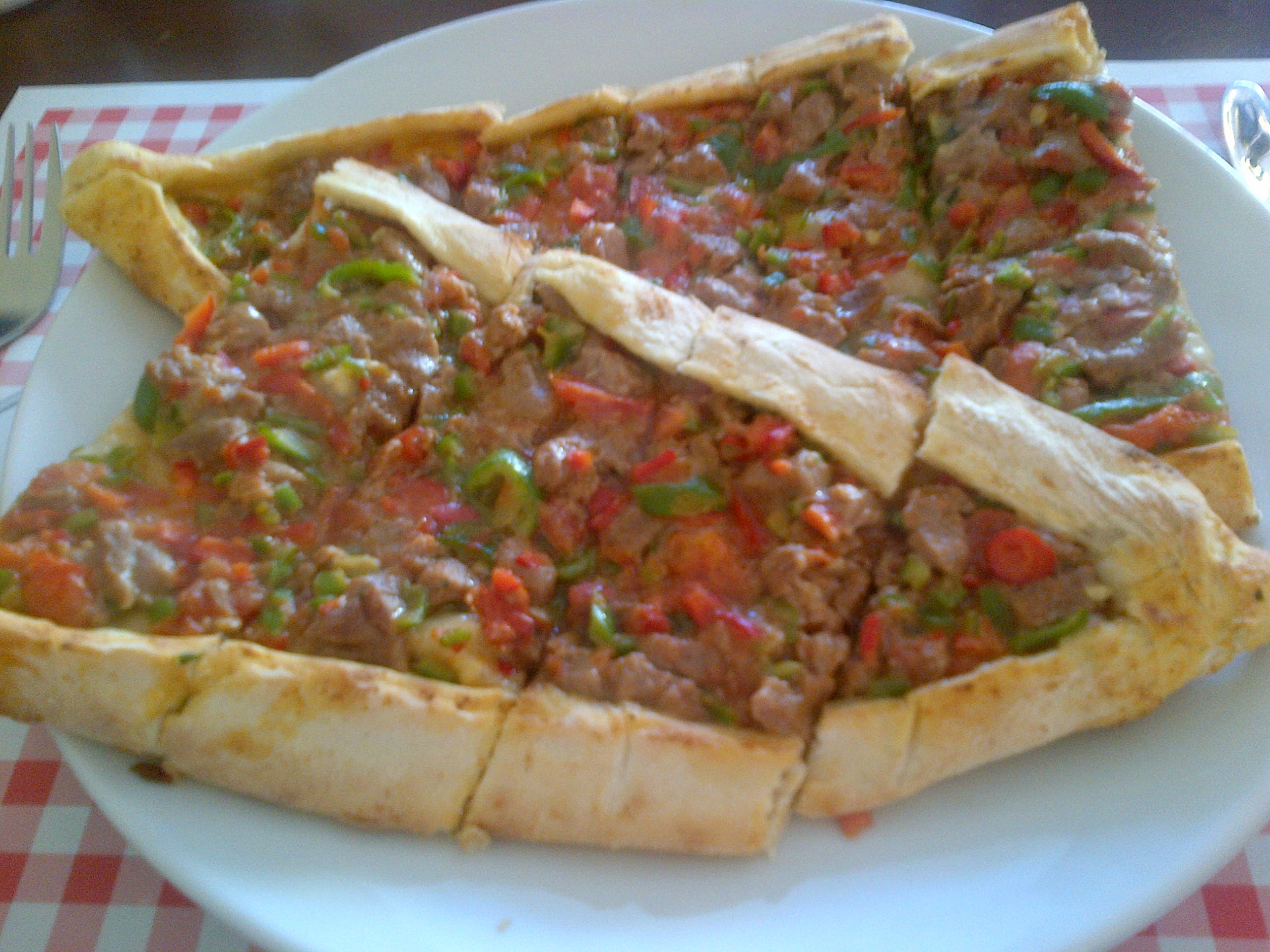 Boat-shaped Turkish pide with meat filling and melted cheese