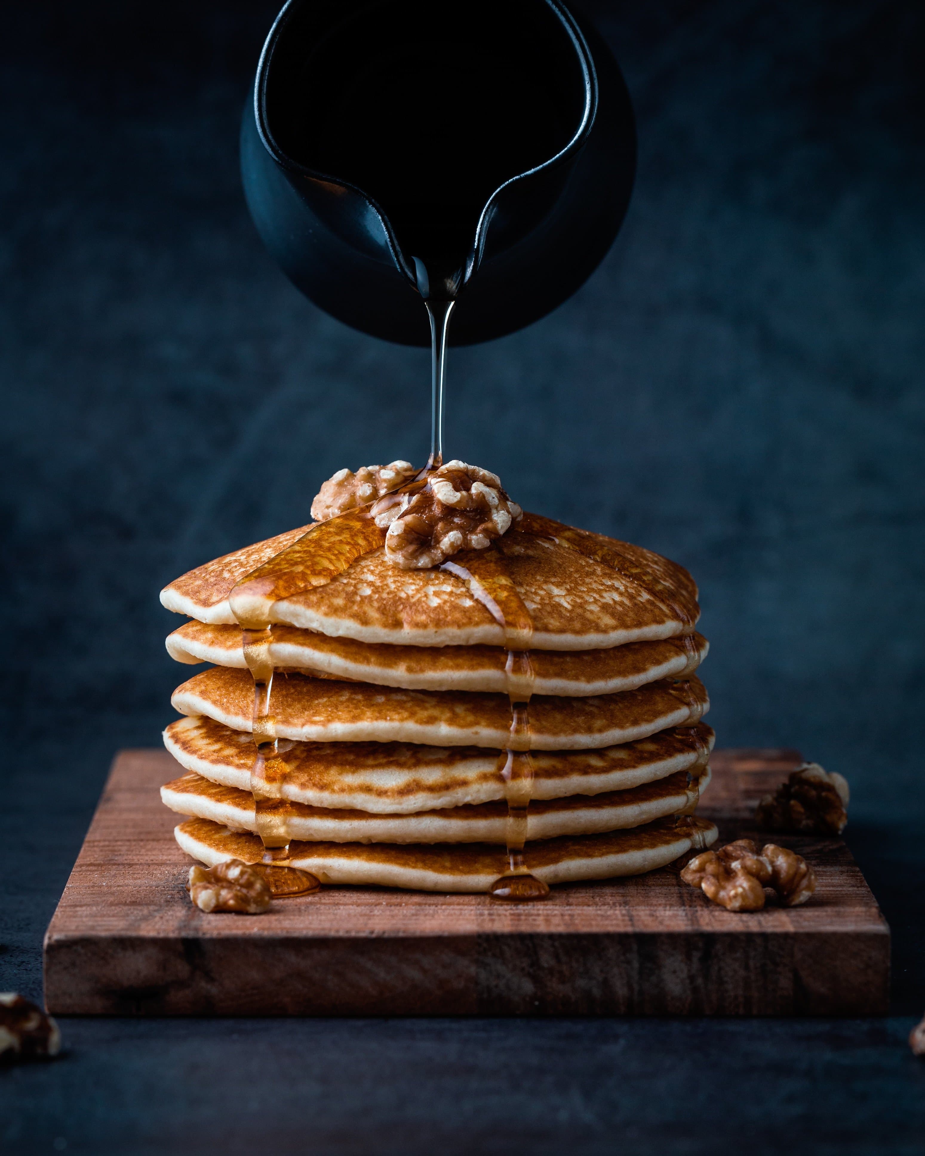 Stack of tall, fluffy Japanese souffle pancakes with butter on top and a dusting of powdered sugar