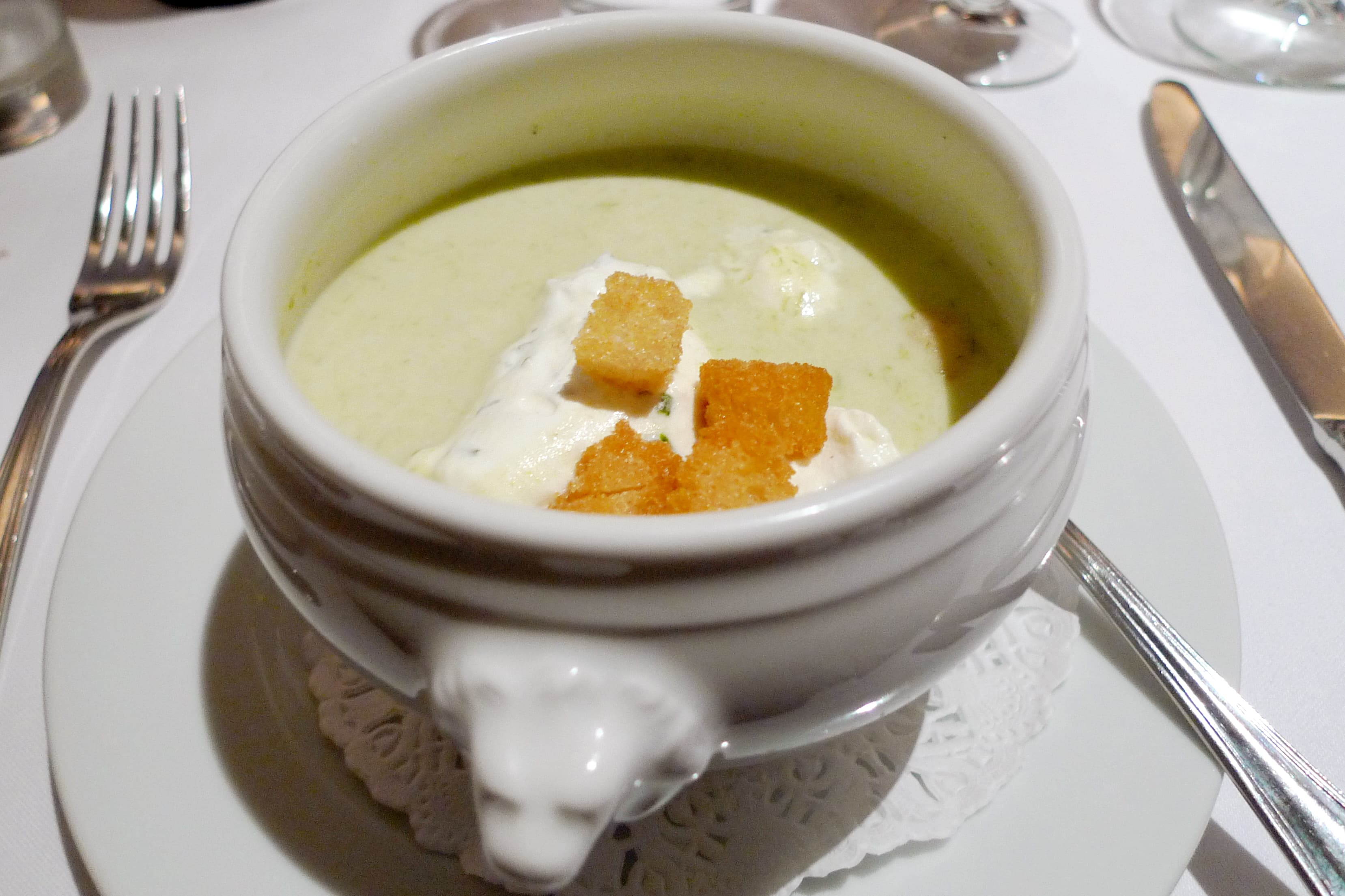 Bowl of velvety potato leek soup garnished with chives and cream